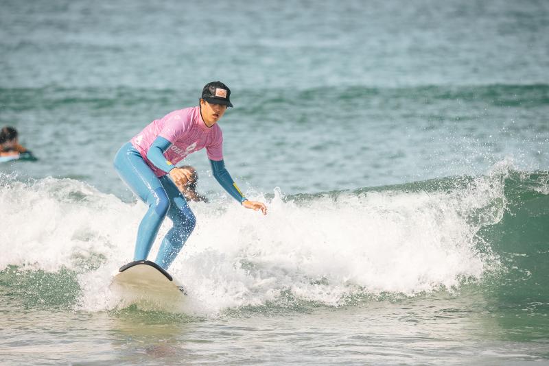 Een jongen is aan het surfen tijdens zijn zomerkamp Portugal